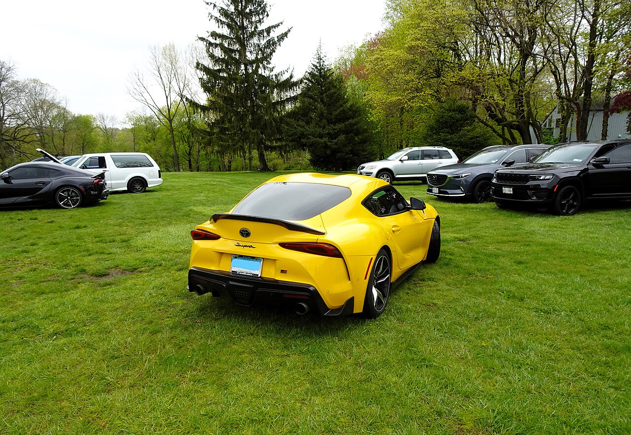 Real-world yellow Toyota GR Supra at an outdoor car gathering